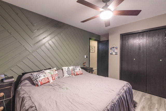 bedroom with ceiling fan, light hardwood / wood-style flooring, and a closet