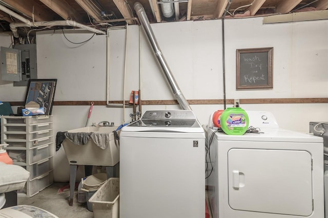 clothes washing area featuring washer and clothes dryer, sink, and electric panel