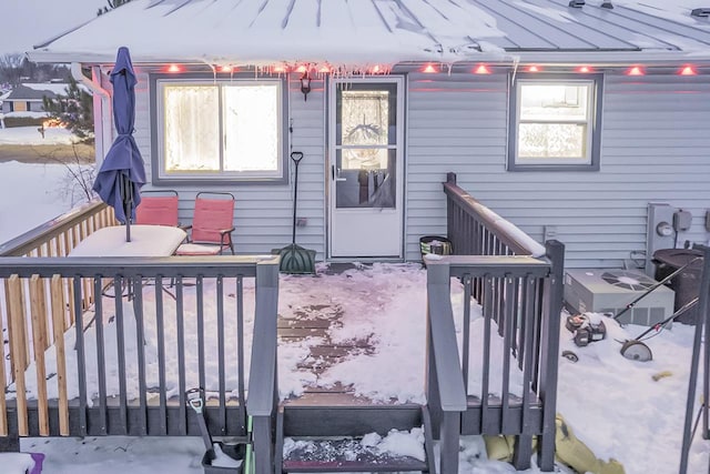 snow covered property entrance with a deck