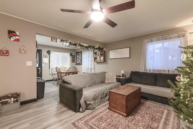 living room with wood-type flooring, plenty of natural light, and ceiling fan