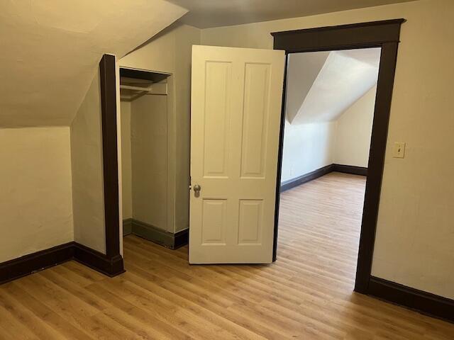 bonus room featuring lofted ceiling and light wood-type flooring