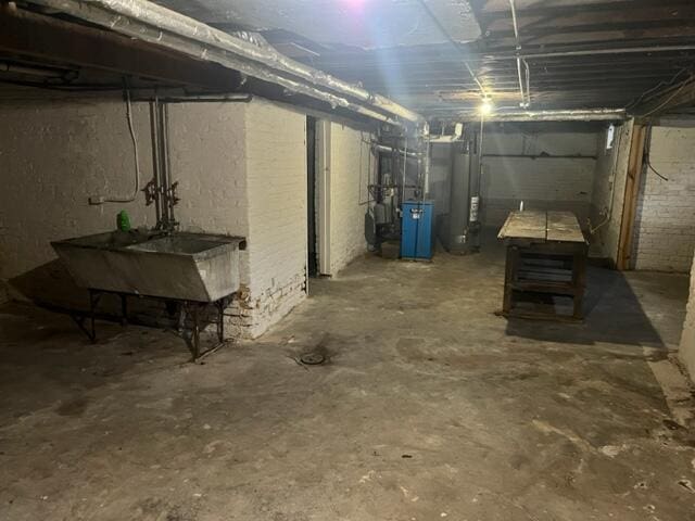 basement featuring sink and water heater