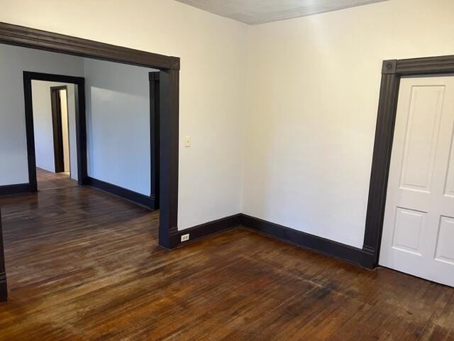 unfurnished room featuring dark wood-type flooring