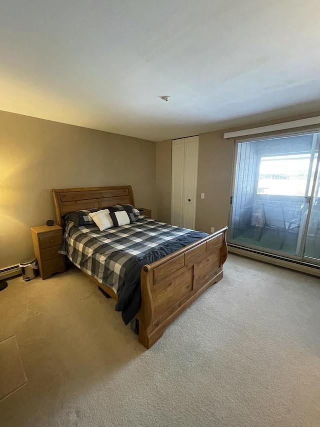 carpeted bedroom featuring baseboard heating and a closet