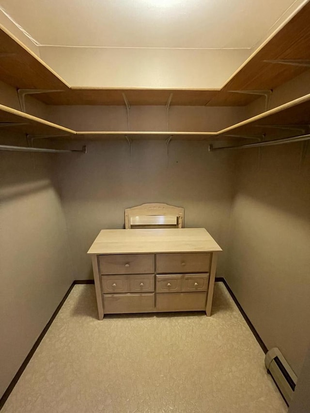 walk in closet with light colored carpet and a baseboard radiator