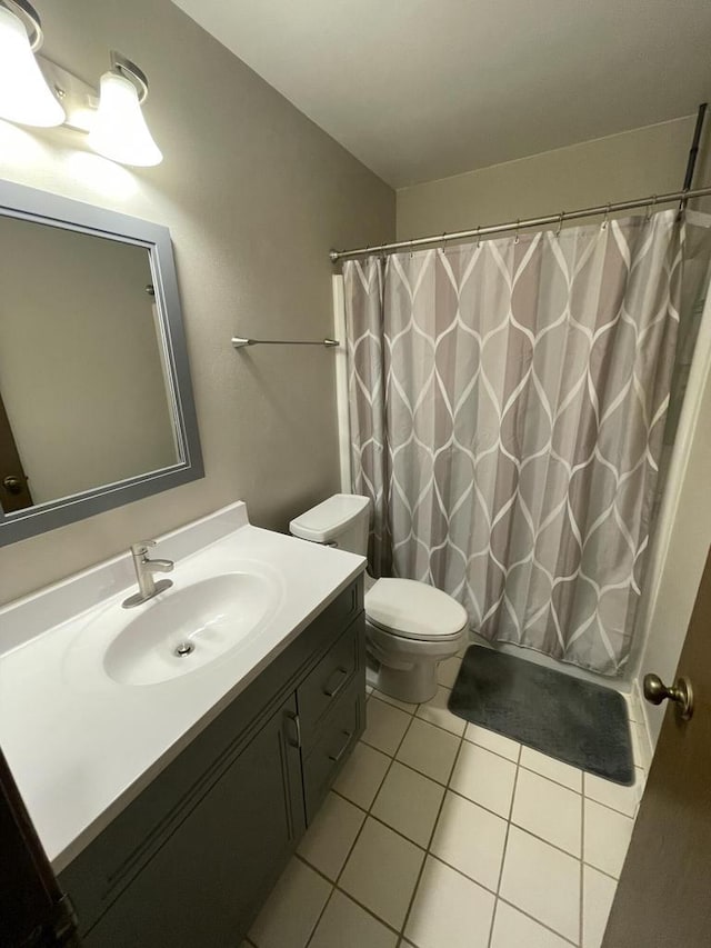 bathroom featuring tile patterned floors, vanity, curtained shower, and toilet