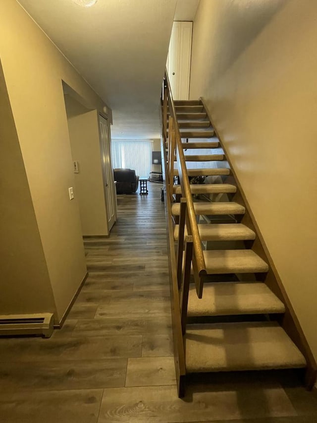 stairway featuring a baseboard radiator and hardwood / wood-style flooring