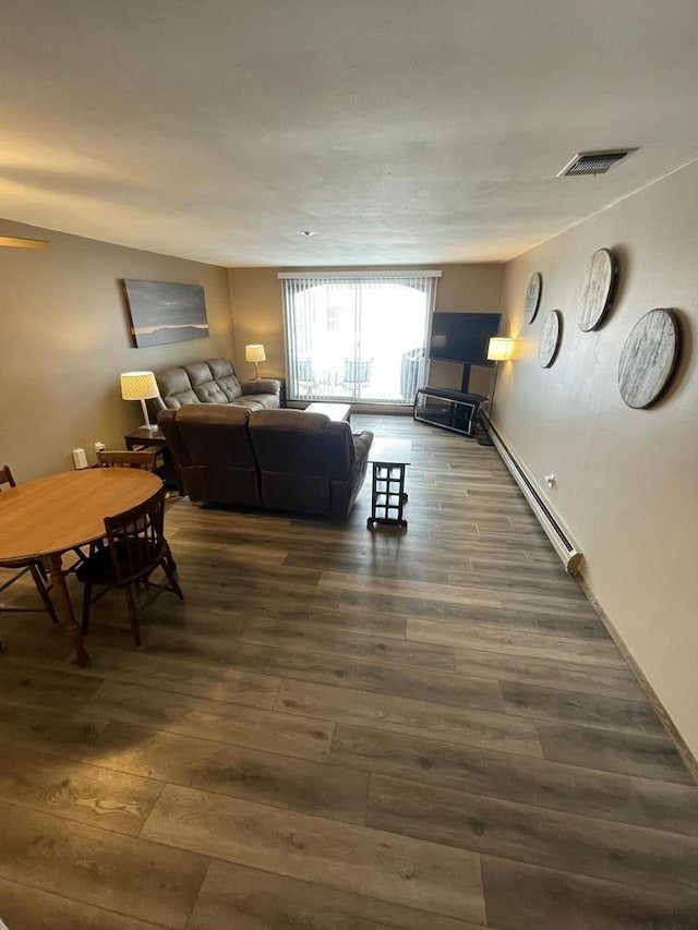 living room featuring baseboard heating and dark wood-type flooring