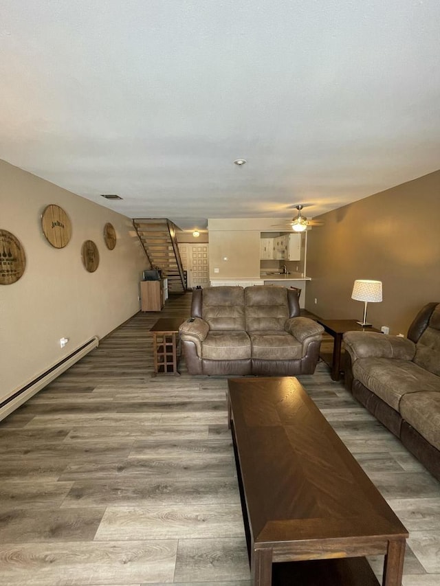 unfurnished living room featuring hardwood / wood-style flooring, a baseboard radiator, and ceiling fan