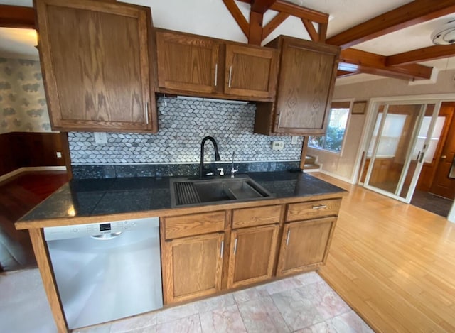 kitchen featuring dishwasher, sink, tasteful backsplash, beamed ceiling, and light hardwood / wood-style floors