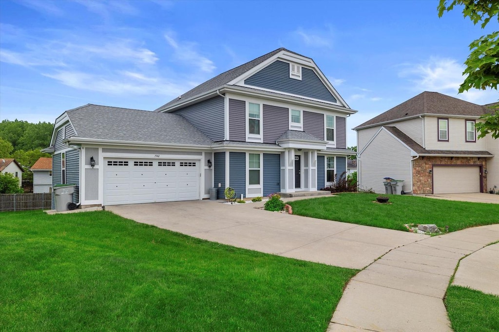 view of property featuring a front lawn and a garage