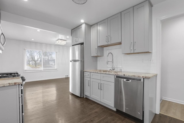 kitchen with gray cabinetry, sink, appliances with stainless steel finishes, and dark wood-type flooring