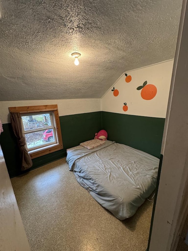 bedroom featuring lofted ceiling and a textured ceiling