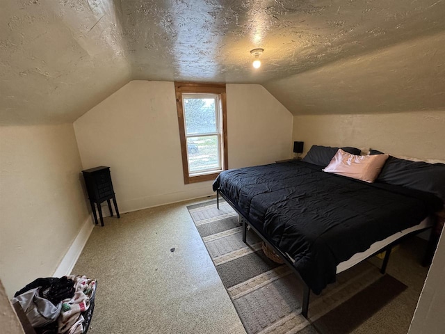 carpeted bedroom with vaulted ceiling and a textured ceiling