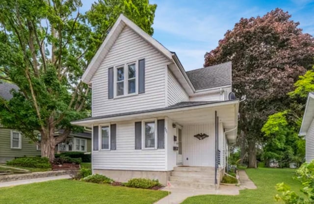 front of property featuring a front lawn and covered porch