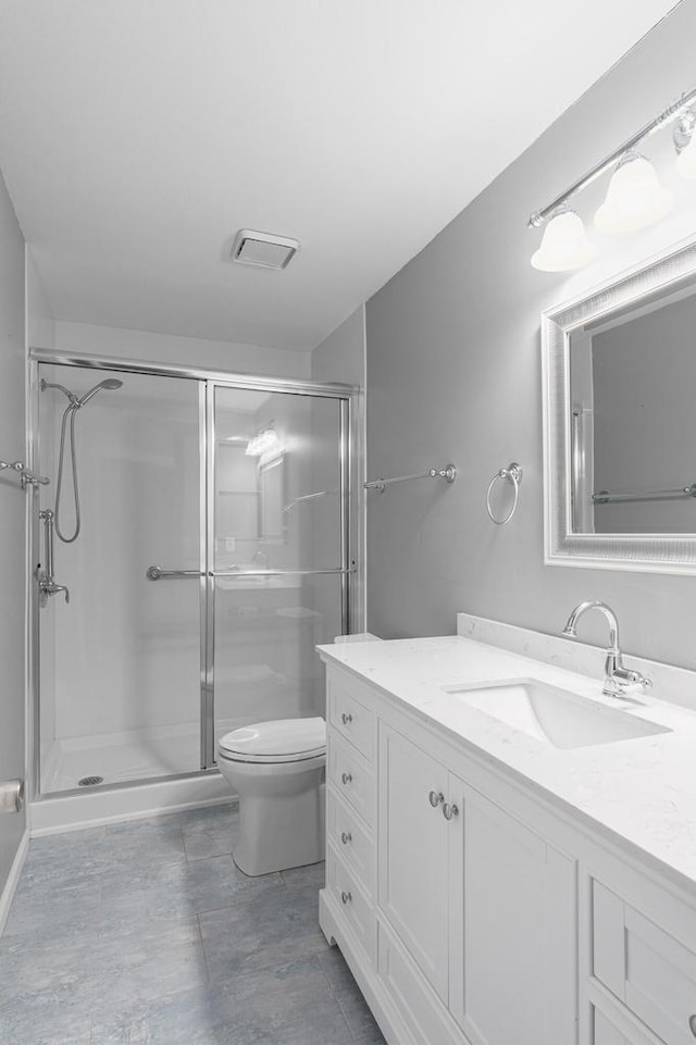 bathroom featuring an enclosed shower, vanity, and toilet