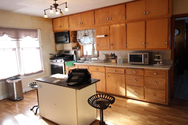 kitchen featuring plenty of natural light, sink, appliances with stainless steel finishes, and light hardwood / wood-style flooring