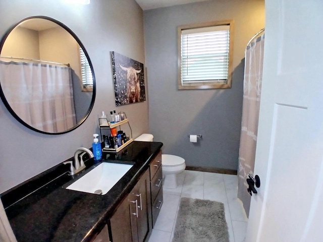 bathroom with tile patterned flooring, vanity, and toilet