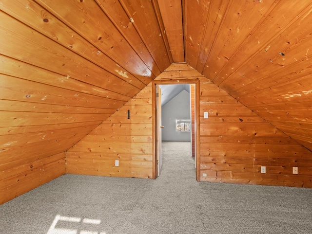 bonus room featuring lofted ceiling, wood walls, carpet floors, and wood ceiling