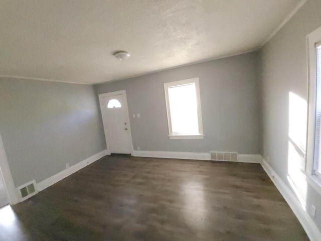 foyer entrance featuring a textured ceiling and dark hardwood / wood-style flooring