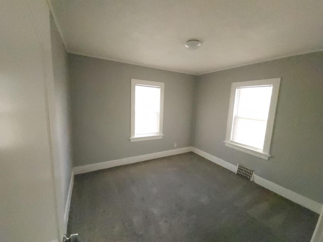 unfurnished room with dark colored carpet