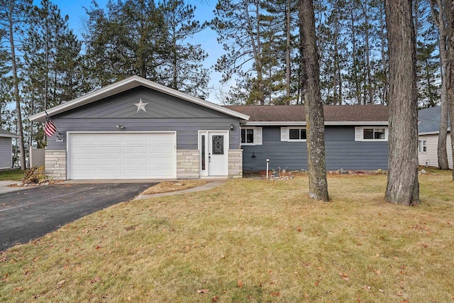 ranch-style house featuring a garage and a front lawn