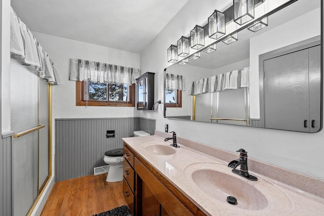 bathroom featuring walk in shower, hardwood / wood-style floors, vanity, and toilet