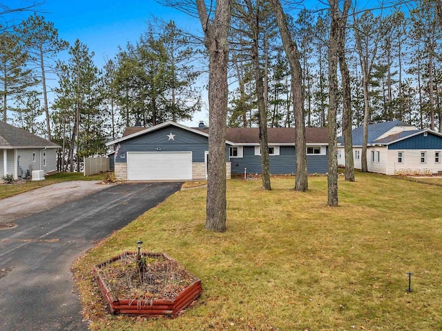 ranch-style home featuring a garage and a front lawn