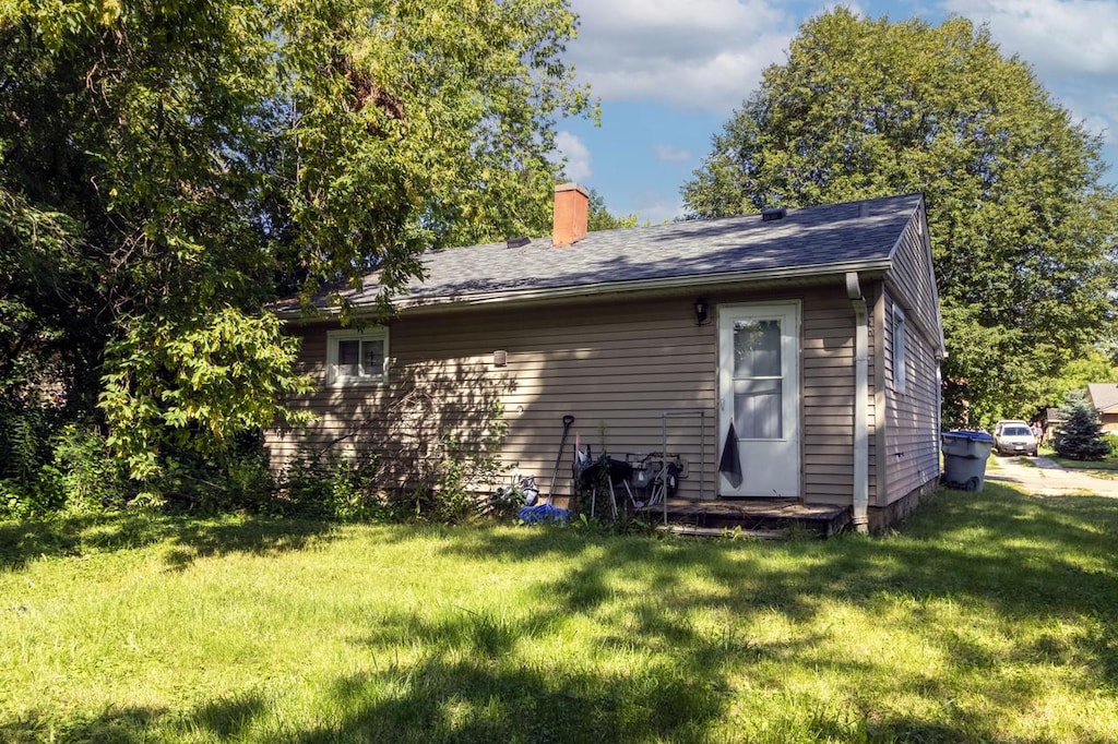 back of property featuring a lawn