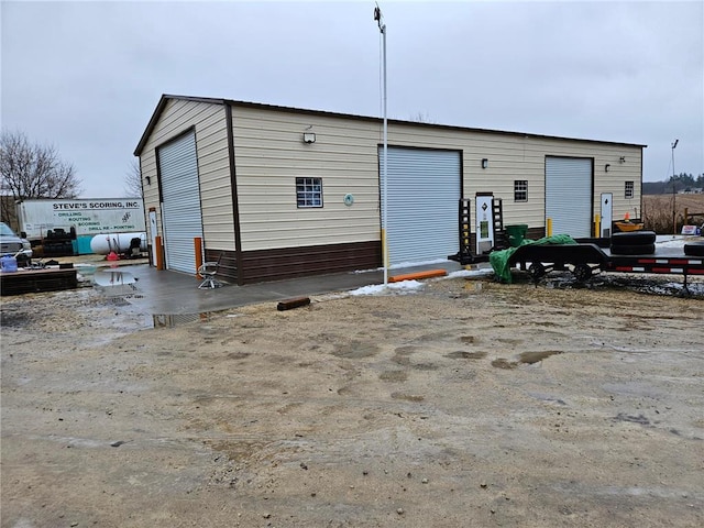 rear view of house featuring a garage and an outbuilding