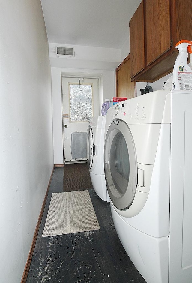 clothes washing area with cabinets and washing machine and clothes dryer