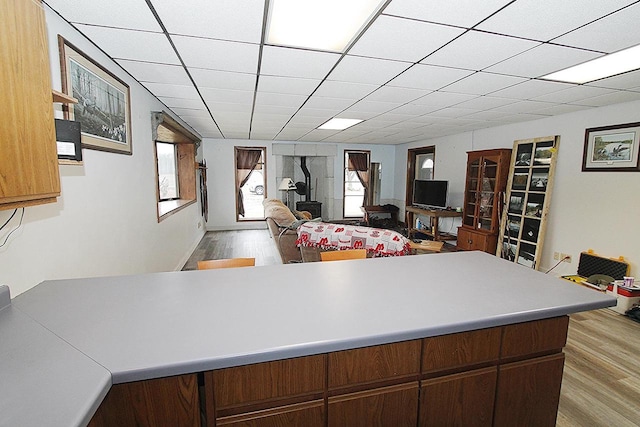 kitchen featuring kitchen peninsula, a paneled ceiling, and light hardwood / wood-style flooring