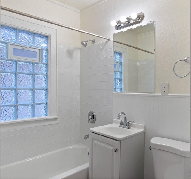 full bathroom featuring tiled shower / bath combo, toilet, and vanity