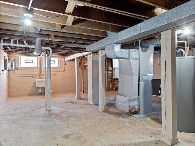 basement with heating unit, sink, electric panel, and water heater