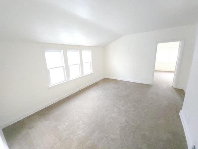 empty room with carpet and vaulted ceiling