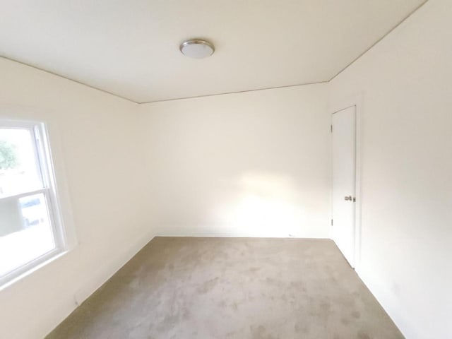 unfurnished room with plenty of natural light and carpet