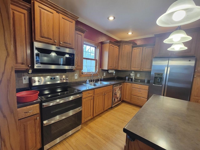 kitchen featuring sink, stainless steel appliances, tasteful backsplash, decorative light fixtures, and light wood-type flooring