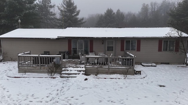 snow covered house featuring a deck