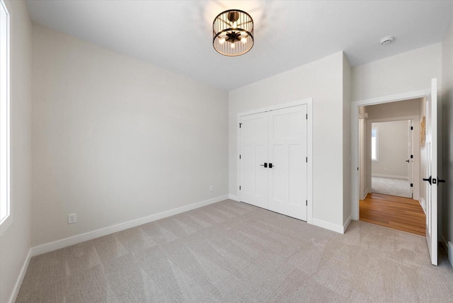 unfurnished bedroom featuring light colored carpet and a closet