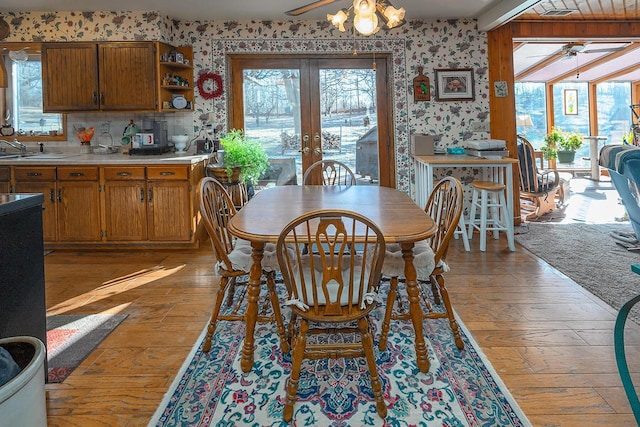 dining area with ceiling fan, french doors, sink, and light hardwood / wood-style floors