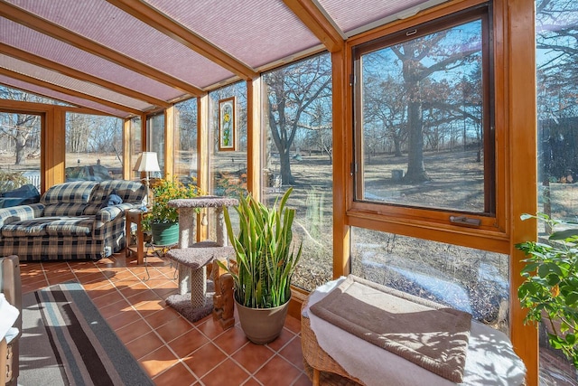 sunroom / solarium featuring vaulted ceiling with beams