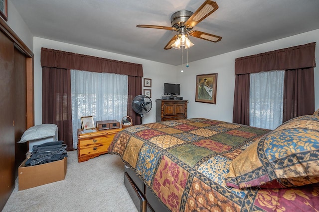 carpeted bedroom with ceiling fan and a closet