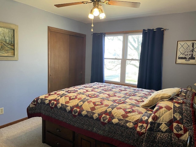 carpeted bedroom featuring ceiling fan and a closet