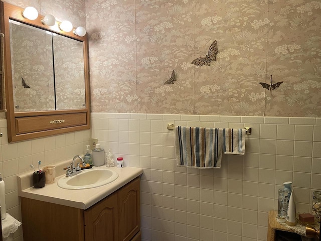 bathroom with vanity and tile walls