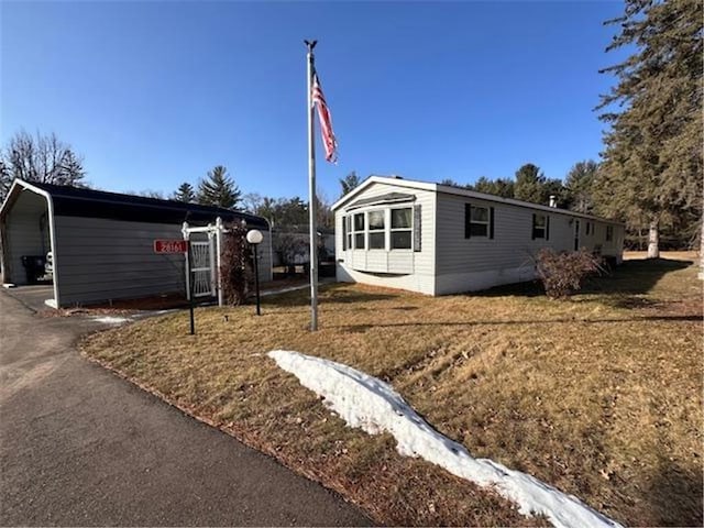 view of property exterior with a carport and a yard