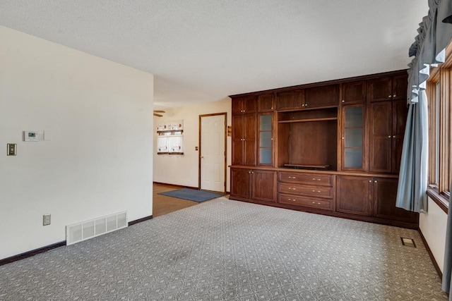 unfurnished living room with dark carpet