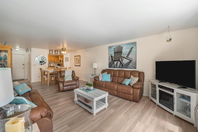 living room with light hardwood / wood-style floors and ceiling fan