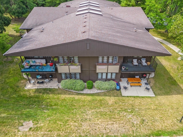 rear view of house with a lawn, an outdoor living space, and a patio area