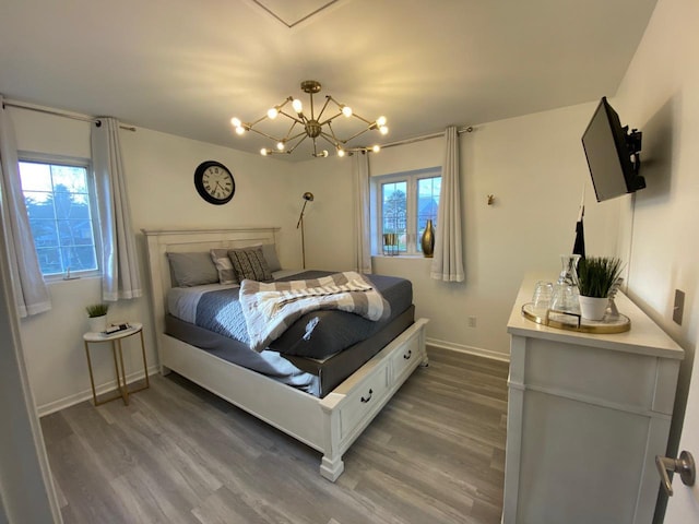 bedroom with dark wood-type flooring and an inviting chandelier