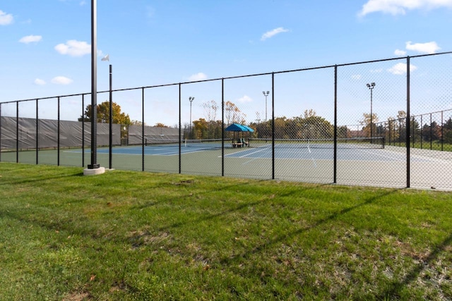 view of tennis court with a yard